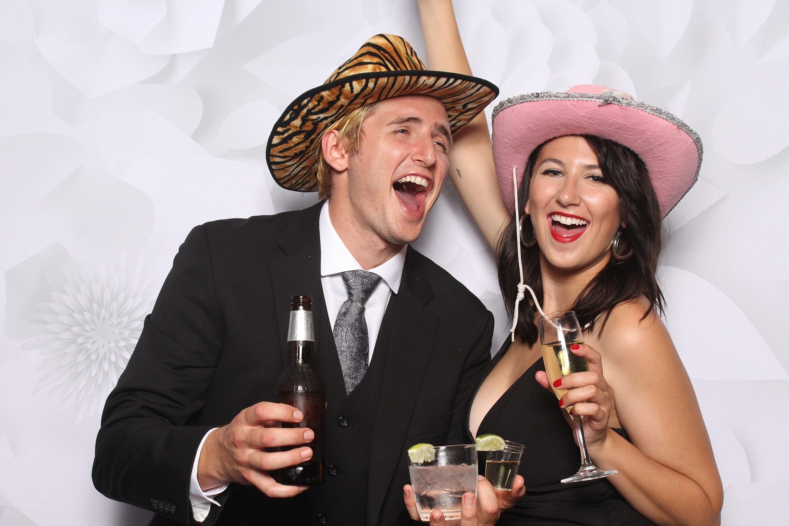 Happy couple posing with props at wedding photo booth